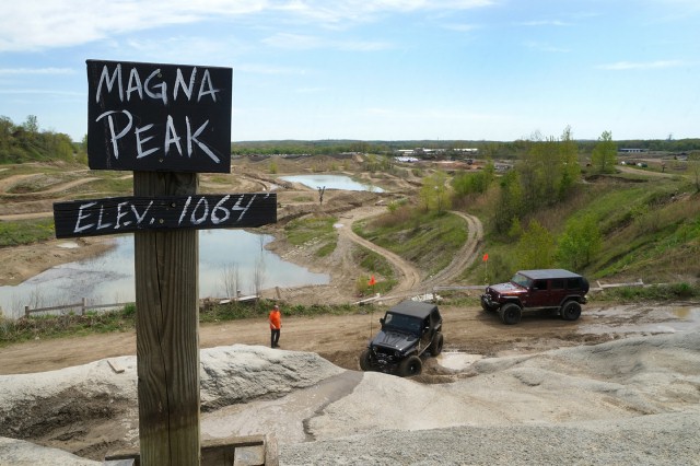 Sign at Holly Oaks ORV Park that says "Magna Peak" and has two jeeps in the background